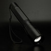 A Swiss Peak 10W Cree Torch features a sleek black design with a textured grip and a wrist strap for easy handling.