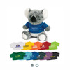 A grey koala plush toy sits upright, wearing a blue shirt. Multiple colourful shirts are displayed below it.
