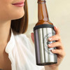 A drink bottle cooler in stainless steel with a black top, holding a brown glass beer bottle. Features a logo.