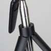 A black tripod with a metallic silver section, featuring a phone holder attachment.