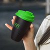 A drink bottle with a black body and green lid, featuring a logo on the side.