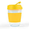 A reusable coffee cup with a clear glass body, yellow silicone sleeve, and yellow flip lid. It features a logo.