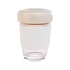 A reusable coffee cup in white with a beige silicone band and a speckled beige lid. It features a branding logo.