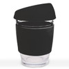 A reusable coffee cup with a transparent glass body and a black silicone lid and sleeve.