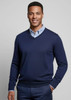 A navy knitted jumper with a V-neck and fitted cuffs, worn over a light blue collared shirt. Features a logo.