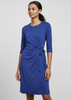 A blue women's dress features three-quarter sleeves and a tied waist detail, set against a neutral background. It has branding.