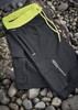 A pair of black sports shorts with a neon yellow waistband and drawstring, featuring a logo.