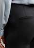 A close-up of black women's leggings, featuring a back pocket and part of a light blue top.