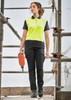 A woman wearing bright yellow and black cargo pants, standing on scaffolding with a power tool, showcasing the cargo pant design.