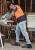 A man wearing men's stretch jeans in a light blue colour, working with a saw in a workshop environment.