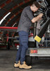 Mens Streetworx Heritage Pant in navy, paired with tan work boots, worn by a man repairing machinery in a hangar.