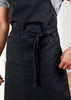 A black apron featuring a waist tie and front pockets, designed for practical workwear use.