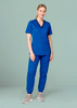 A woman wearing blue women's Riley slim leg jogger scrub pants paired with a matching scrub top, standing against a light background.