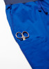 A pair of scissors tucked into the pocket of blue jogger scrub pants.