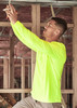 A man wearing a high visibility long sleeve tee in fluorescent yellow, working on electrical wiring in a construction setting.