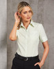 A light green women's button-up shirt with short sleeves and a pocket, featuring a logo on the collar.