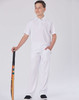 A boy stands proudly in a white cricket polo shirt and matching trousers, holding a cricket bat. The outfit features a logo.