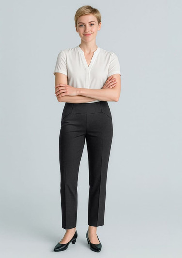 A woman wearing black slim leg pants and a white top, smiling with arms crossed. The pants feature a bandless design.