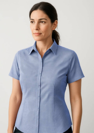 A short-sleeve button-up shirt in light blue, featuring a checkered pattern and a collar. It has a logo on it.