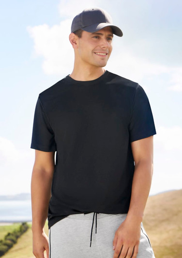 A black men's short sleeve tee worn by a model, paired with grey shorts and a cap in a scenic outdoor setting.