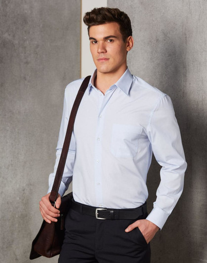 A light blue long-sleeve button-up shirt with a chest pocket, worn by a man holding a brown bag.