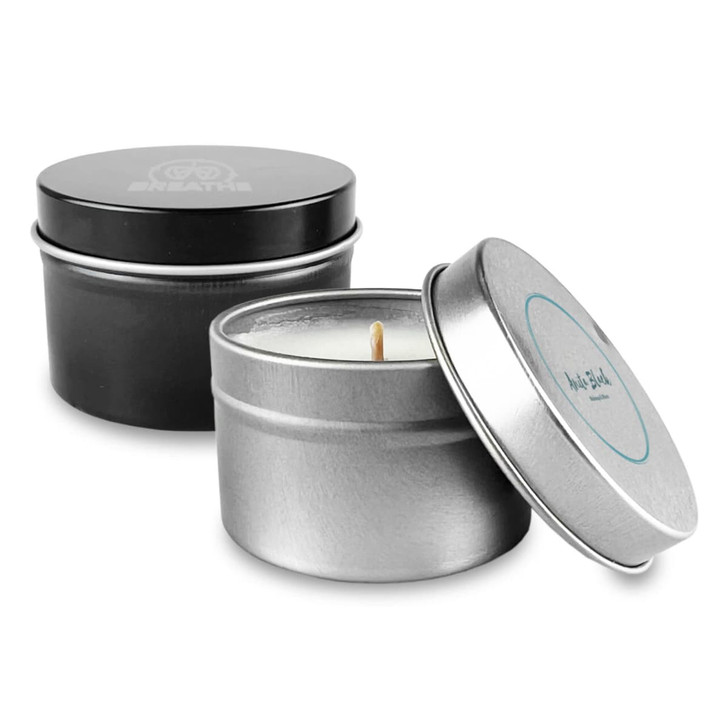 A tin candle set featuring a silver and black container with a visible wick. Both tins have different designs.