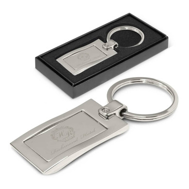 A silver metal key ring in a black presentation box with an engraved design.