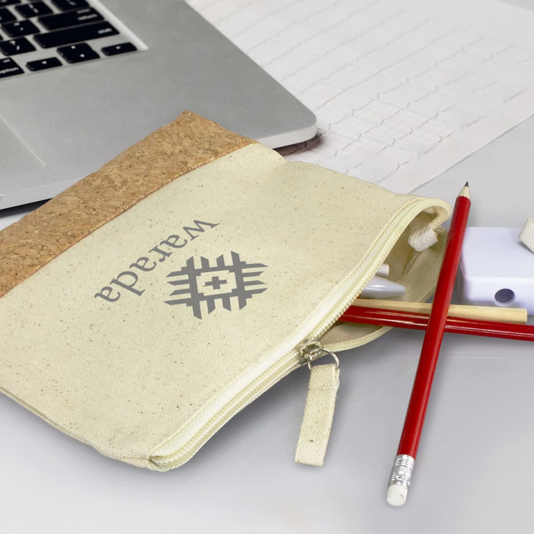 A cream and cork pencil case containing pens, pencils, and a small eraser, with a logo on the front.