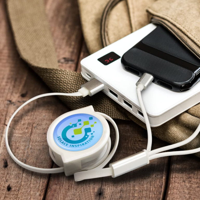 A white retractable charging cable connected to a power bank, resting on a textured surface.