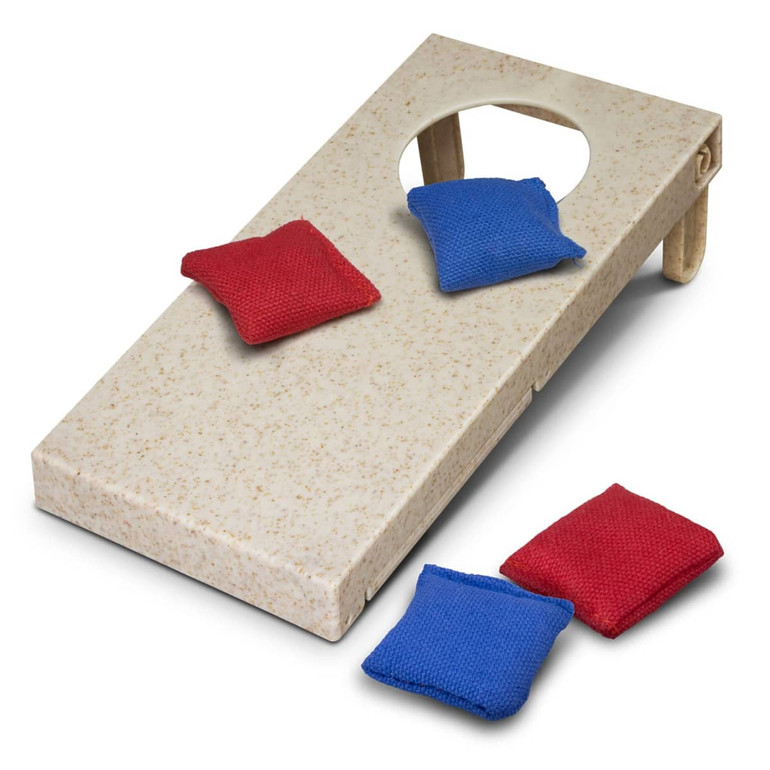 A cornhole game featuring a light-coloured board with a hole and red and blue bean bags.