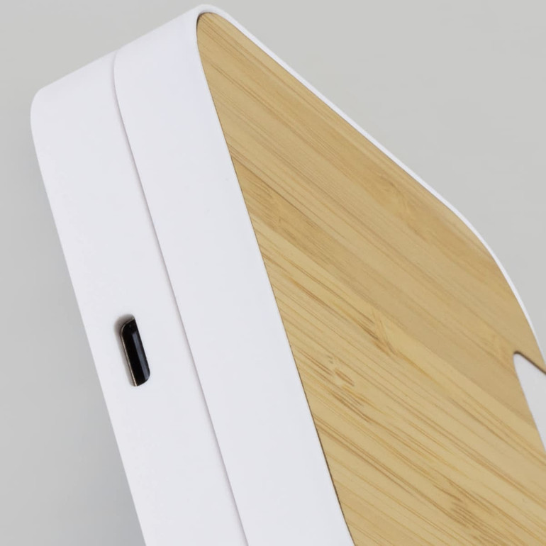 A wireless fast charging stand featuring a white base and a bamboo top, with a USB-C port.