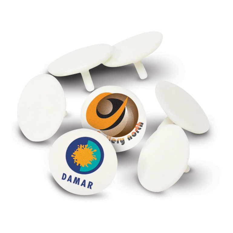 A set of white plastic golf ball markers, featuring various logos on some markers.