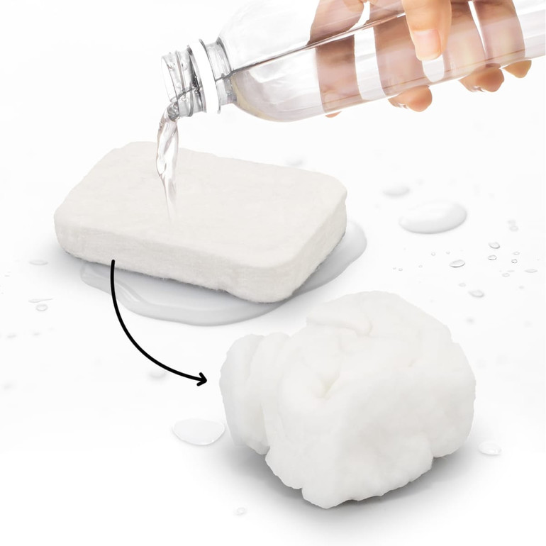 A small compressed towel in white, next to a hand pouring water from a clear drink bottle.