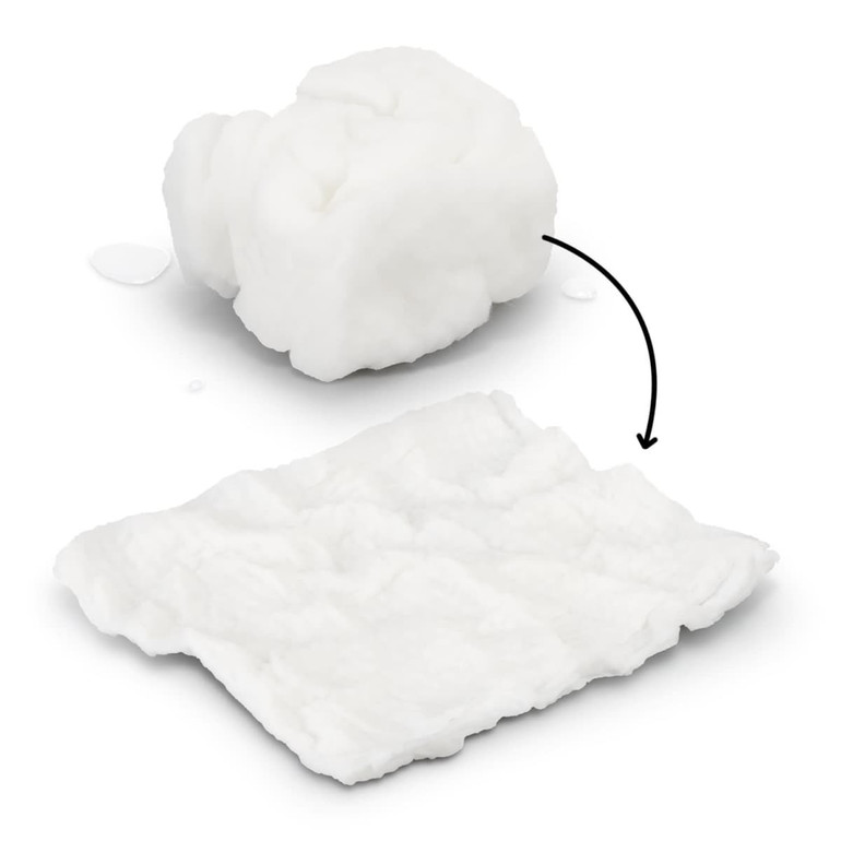 A compressed white towel, transforming from a small compact shape to a flat, textured cloth, with water droplets nearby.