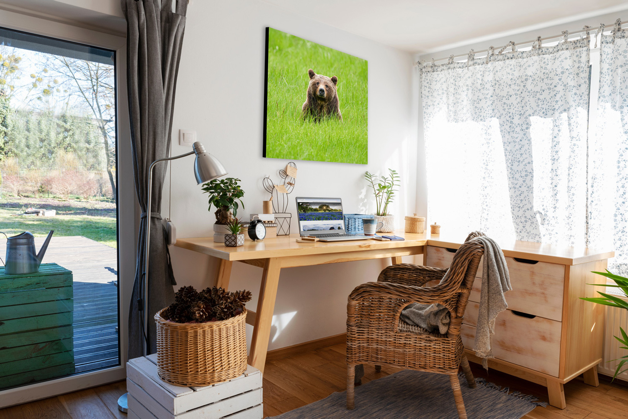 Wrapped canvas of “One Special Bear” displayed in a cozy corner nook workspace above a small desk, showing Grizzly 399 seated peacefully in a spring meadow—her calm, watchful gaze adding emotional depth and natural inspiration to the work environment.