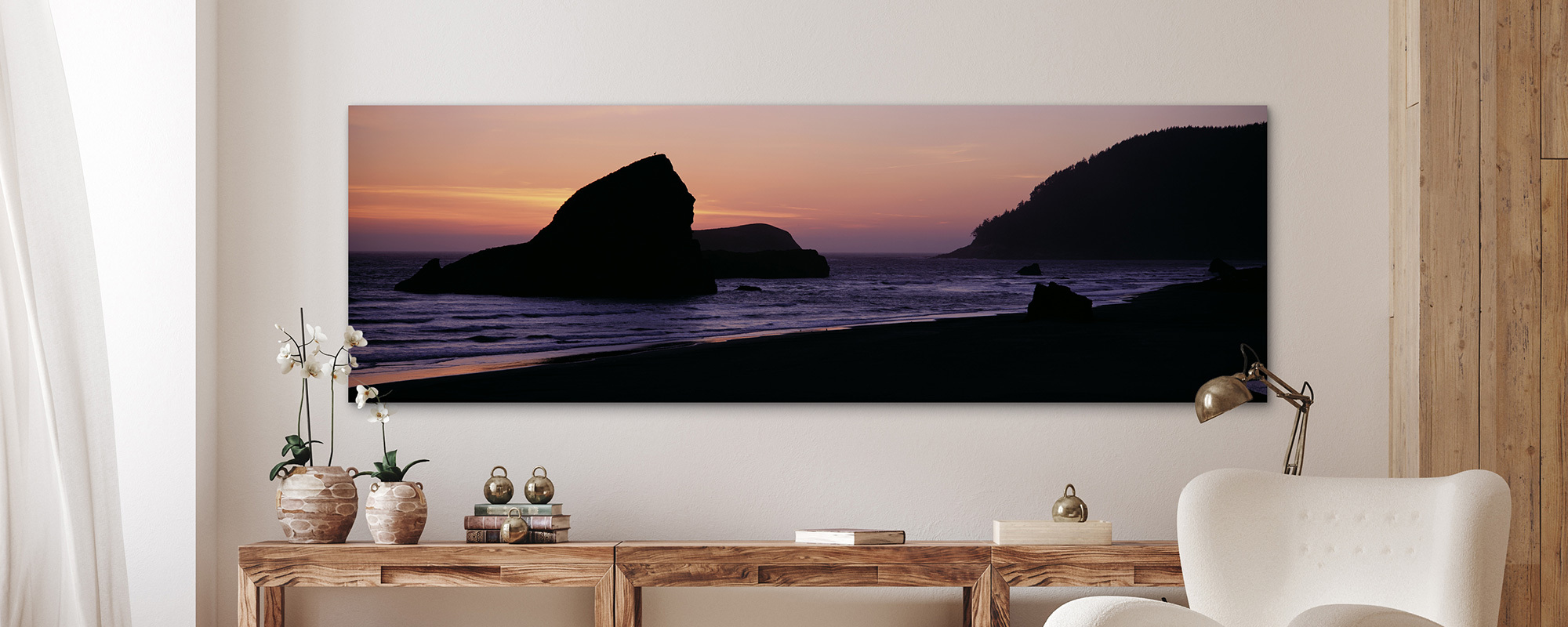 Mule deer stands on a solitary sea stack on an Oregon beach at sunset.