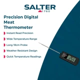 Digital meat thermometer checking doneness of roast beef on wooden board