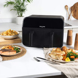 Black Salter dual air fryer on kitchen counter with cooked chicken, chips, and vegetables