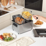 Silver deep fat fryer with two baskets, shown from front left angle.