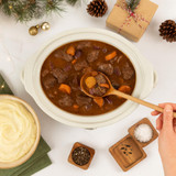 Cream slow cooker with beef stew, served with mashed potatoes, salt and pepper