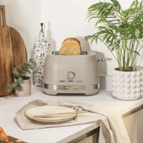 Taupe 4-slice toaster with slices of bread, shown on kitchen counter