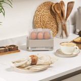 Taupe Salter egg cooker with lid holding eggs, on kitchen counter.