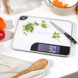 Digital kitchen scale with chopped herbs and knife on white surface, Salter brand