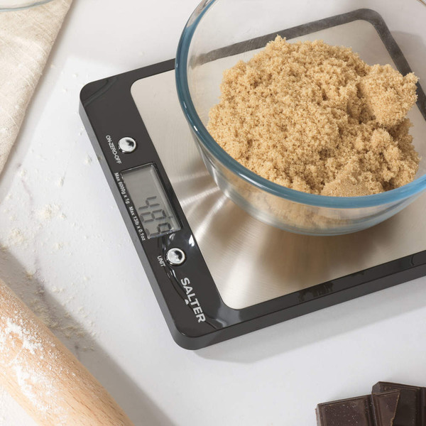 Digital kitchen scale weighing brown sugar in glass bowl, showing 498g