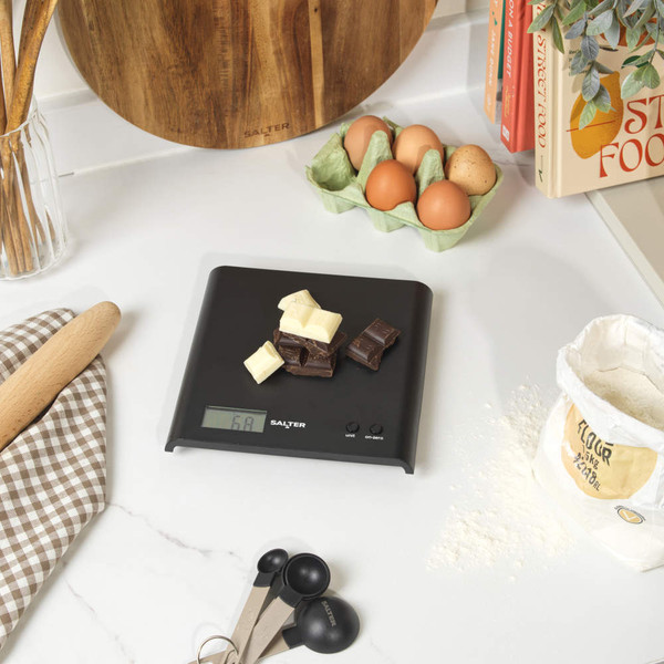 Black digital kitchen scale with display showing weight, Salter branding
