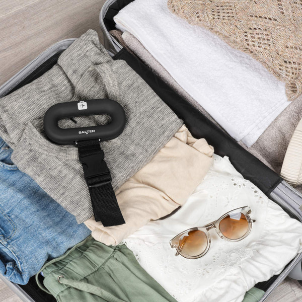 Black digital luggage scale with LCD display, hand shown weighing suitcase. Dimensions visible.