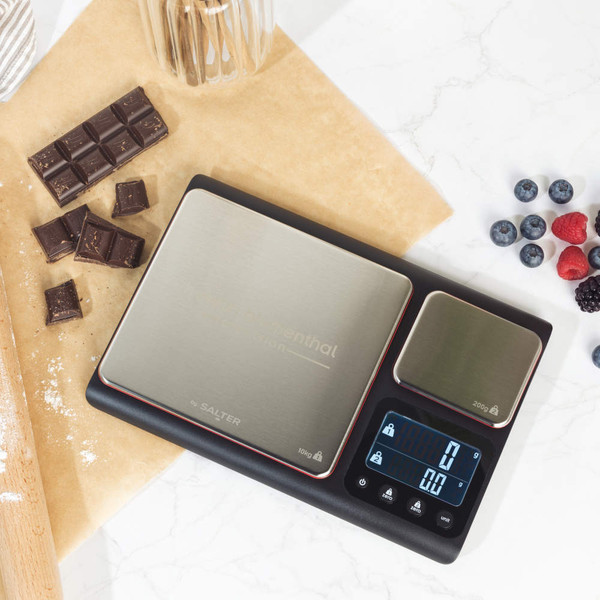 Digital kitchen scale with bowl of brown sugar and chocolate pieces, shown on worktop