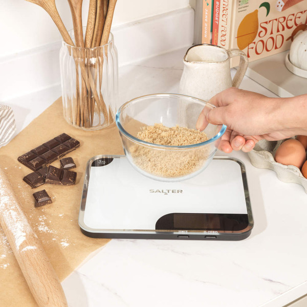 Detail of white Salter digital kitchen scale with silver trim, showing 5kg capacity marking