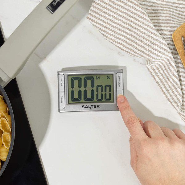 Silver digital kitchen timer attached to fridge door, display showing minutes and seconds