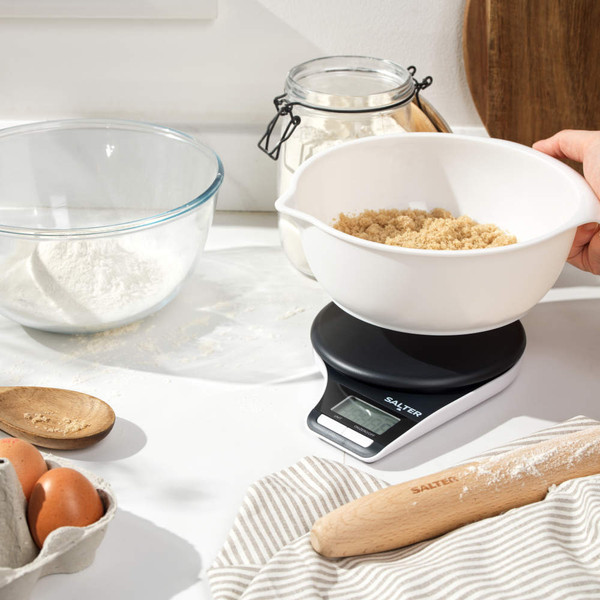 White digital kitchen scale with a bowl of fresh strawberries on display